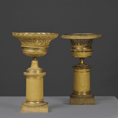 two gold vases sitting on top of a table next to each other