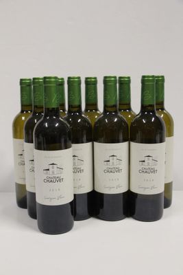 six bottles of wine are lined up in a row on a white surface