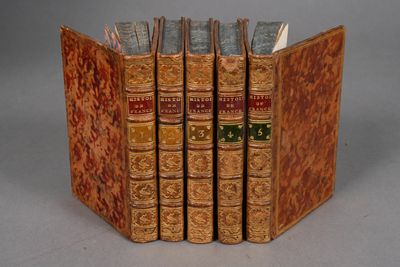 three old books are stacked on top of each other on a table