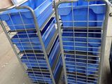 Plusieurs bacs bleus sont empilés les uns sur les autres dans un entrepôt