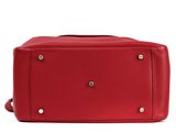 the red leather bag is sitting on a white surface