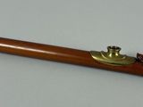a wooden pipe with a brass handle on a table