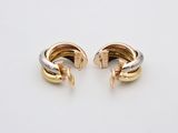 a pair of gold and silver hoop earrings on a white surface