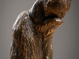 statue en bronze représentant un ours assis sur une table en bois