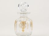 an image of a glass perfume bottle with a gold design on it