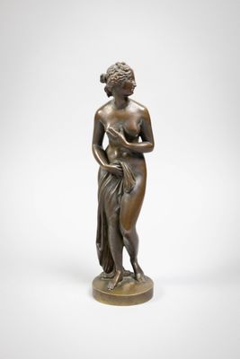 a bronze statue of a woman holding a flower
