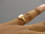 la main d'une femme à laquelle est passée une bague en or