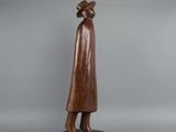 a bronze statue of a woman in a hat and coat