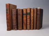 several old books are stacked on top of each other on a white surface