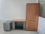 a desk and cabinet in the corner of a room