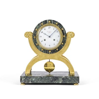 une horloge dorée posée sur un socle en marbre, sur fond blanc