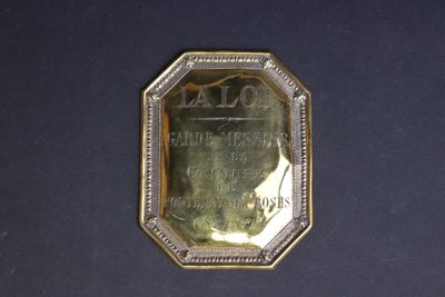 an image of a gold plate with a picture of a man on it