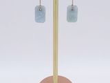 a close up of a pair of earrings on a stand
