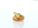 two gold rings on a white surface with a white background