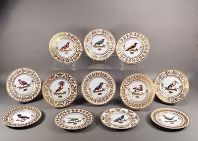 douze assiettes en porcelaine ornées d'oiseaux peints sont disposées en pyramide