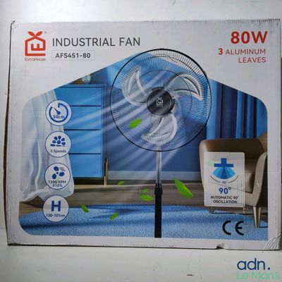 une photo représentant un carton contenant un ventilateur industriel posé à même le sol