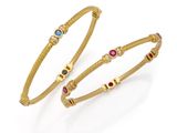 a pair of gold bracelets with multi colored stones