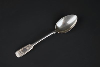 a close up of a silver spoon on a black surface