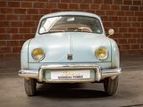 a small blue car that is parked in front of a brick wall
