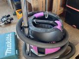 un aspirateur posé par terre à côté d'une boîte à outils