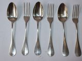 six forks and spoons are lined up on a white surface