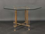 a glass table with gold legs and a clear glass top