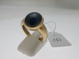 l'image d'une bague en or ornée d'une pierre bleue