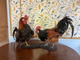 two chickens standing on a wooden table in a room