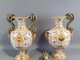 two vases with handles and handles are sitting on a gray surface