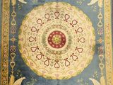 a close up of a rug with birds and flowers on it