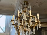 a chandelier in a room with a painting on the wall
