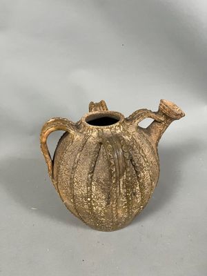 a small brown vase with a handle on a white background
