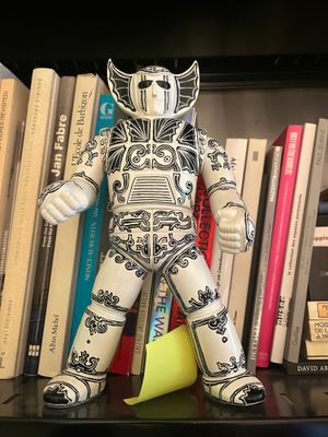 a toy that is sitting on a shelf in front of a bookshelf