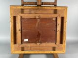 an old wooden easel with a painting on top of it