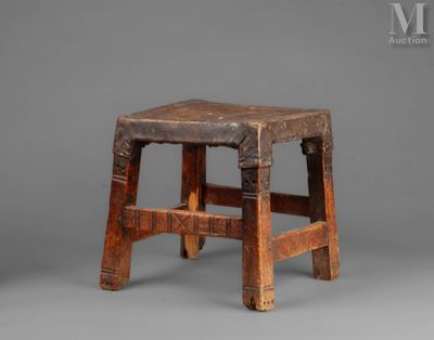 an old wooden stool sitting on top of a gray surface