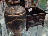 une table en verre sur laquelle se trouve un vase, avec un homme debout à côté