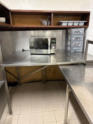 a small kitchen with stainless steel counter tops and a microwave