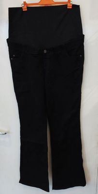 un pantalon noir accroché au mur, avec une ceinture orange