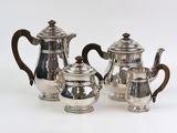 three pieces of silver tea and coffee set on a white surface