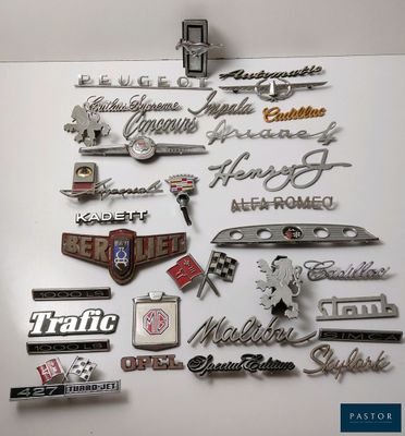 de nombreux types d'emblèmes automobiles exposés sur le mur