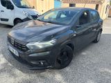 une voiture noire garée sur un parking à côté d'une camionnette blanche