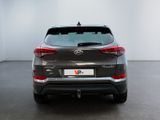 the rear end of a grey suv parked in a white room