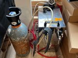 un extincteur et une bonbonne de propane posés par terre