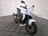 a white motorcycle that is parked on a black and white checkered floor