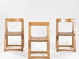 trois chaises en bois sont alignées devant un fond blanc