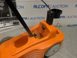 an orange toy car with a black handle on top of a floor