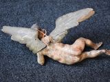 a small angel figurine laying on a blue surface