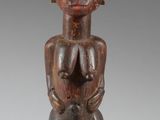 a close up of a wooden statue of a person with horns