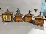 four different types of coffee grinders are lined up on a table