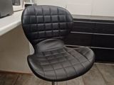 a black chair sitting in front of a desk in a room